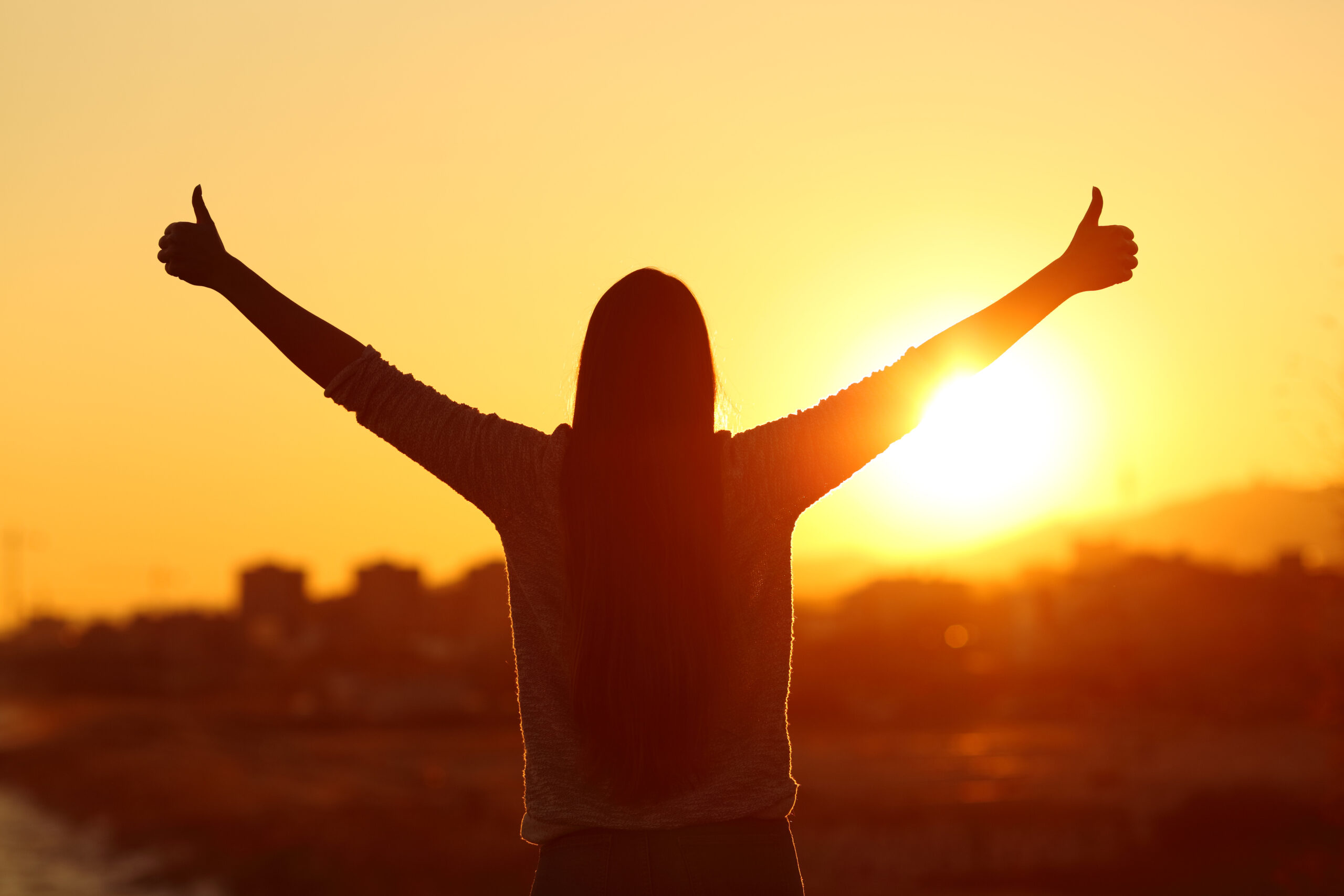 Silhouette of man with two thumbs up for inspiration